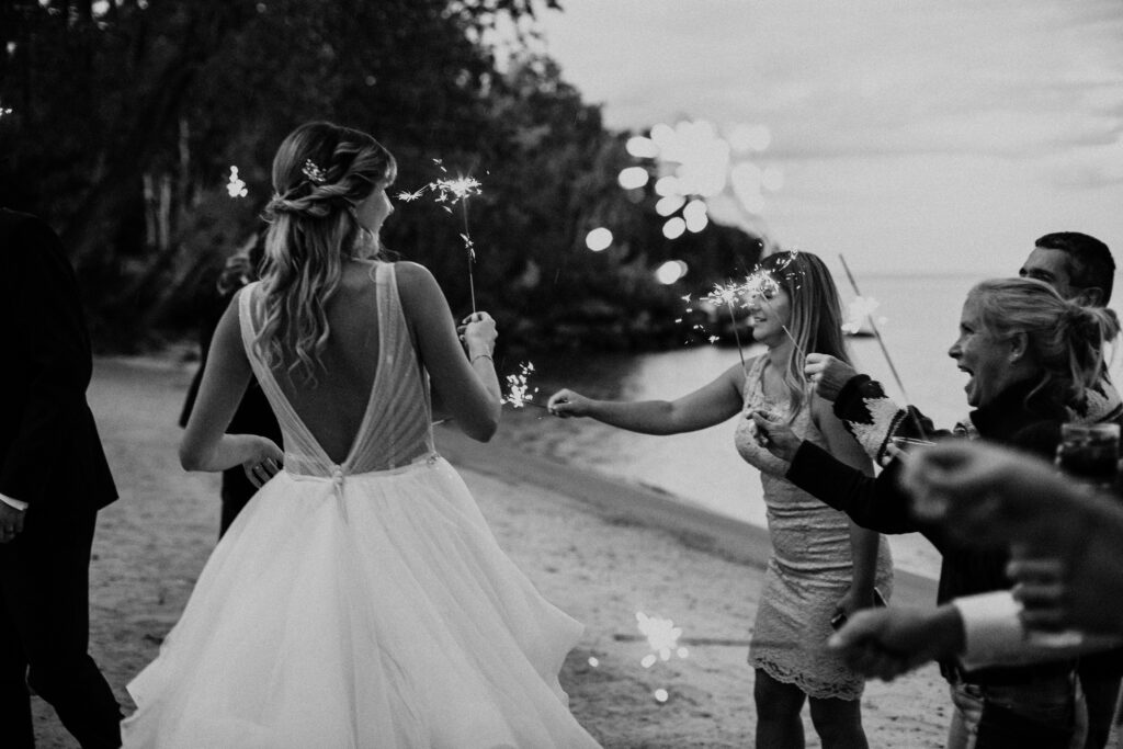 Bride and guests with sparklers on the beach at Hecla Manitoba 