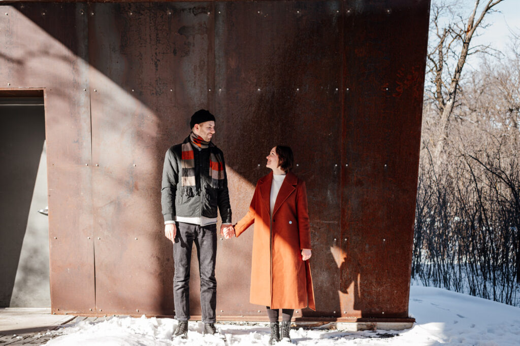 Couple holding hands during Winnipeg winter engagement session at Assiniboine park 